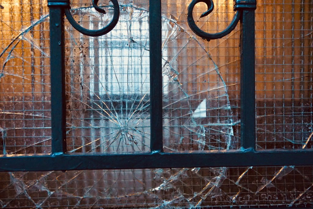 broken window behind iron bars